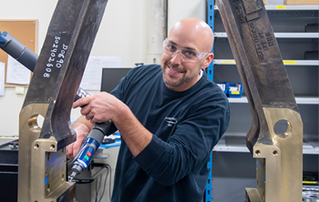 a guy working in an industrial setting with safety glasses on